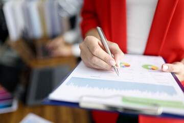 Business woman in red jacket holds clipboard with documents and pen closeup. Maintaining personnel documentation concept.
