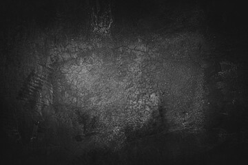 Fototapeta premium Image of cement wall old black grunge with a rough texture and different decorative patterns. There are vignettes and the center of the image is bright. Idea for vintage background with copy space.