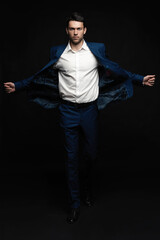 Handsome man wear blue suit isolated on black background