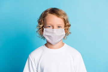 Photo of adorable boy look camera wear medical mask white t-shirt isolated over blue color background