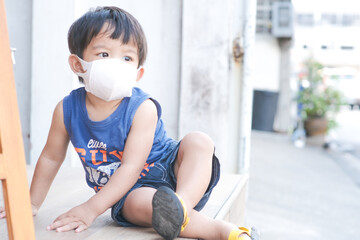 Little boy wear mask sitting in cafe restaurant social distancing