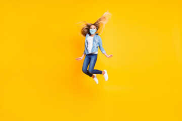 Full body size photo of girl long blonde hair jumping high wear jeans mask shirt isolated on bright yellow color background
