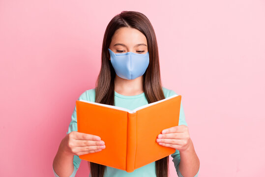 Photo of cute little latin lady hold orange classbook read wear medical mask turquoise sweatshirt isolated pink color background
