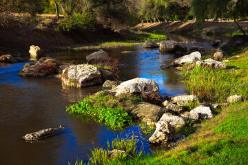 Naklejka na ściany i meble Rocks in the flowing river water 