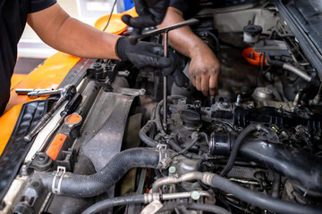 Diesel engine during service, or maintenance at the garage. The internal design of the old engine. Mechanical guy using a screwdriver to remove nuts from the engine box. Engine car spare part