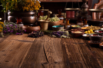 Natural medicine theme. Assorted dry herbs in bowls and brass mortar on rustic wooden table.