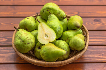 Bio sweet fresh pears from the farm. Healthy Organic Pears in the Basket on wooden rustic background. Healthy food full of vitamins. Pear harvest.Autumn nature concept. Tasty vegetarian snack.