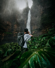 person in the forest with waterfall