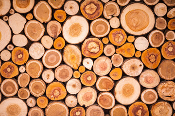 Christmas texture background of dry wooden log cabins. Woodpile of cut Lumber for forestry industry