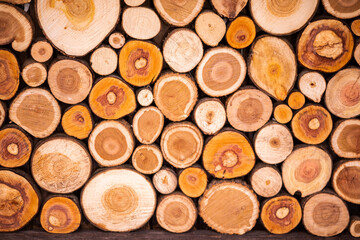 Christmas texture background of dry wooden log cabins. Woodpile of cut Lumber for forestry industry