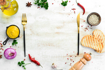 Kitchen banner: Spices, vegetables and cutlery on a white wooden background. Top view. Free space for text.