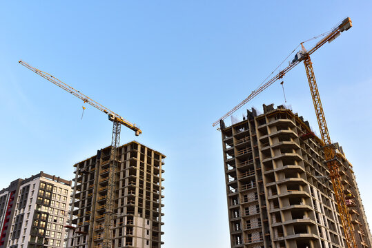 Tower cranes in action at construction site. Construction of skeleton of new modern residential buildings. Preparing to pour of concrete into formwork. Erection multi-storey residential building