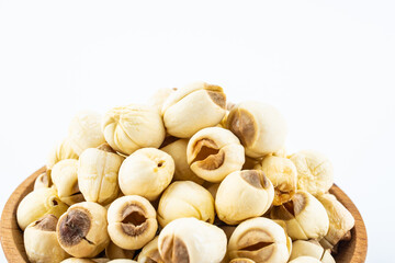 Dried white lotus seeds in a saucer on white background