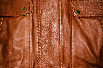 Red brown leather background with stitched seams.