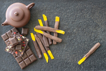 Sweets and chocolate on a black background. Morning tea with chocolate cake