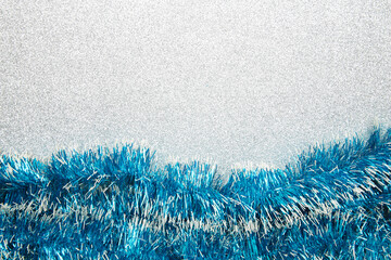 Christmas blue tinsel on silver glittering background. This has clipping path.