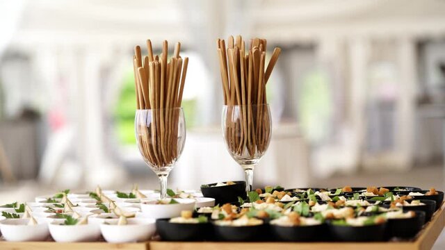Glasses with sticks to pique the appetizers of the festive aperitif of a chic event. The atmosphere is clear, the plan is semi close together, there is a lot of bokeh. The small fillings are delicious