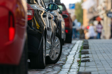 rows of cars parked along the roadside in crowded city