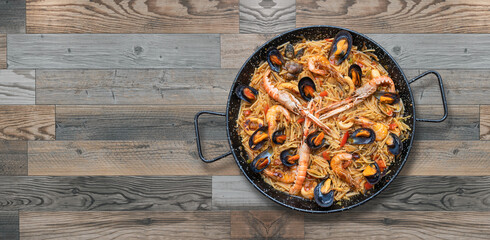 Seafood pasta paella, spanish cuisine isolated on wooden background,copy space