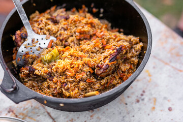 Preparation of raditional armenian pilaf in a cauldron on an open fire