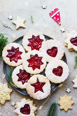 Plate with Christmas or New Year shortcrust cookies with red jam. Traditional festive Austrian cookies with jam. Linzer cookies.