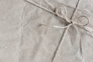 Eco-friendly Christmas gift wrapped in kraft paper  tied with twine close-up. Top view, copy space.