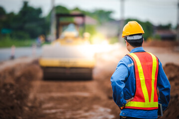 Asian engineers watch road rebuilding and inspect the construction of the road at the construction...