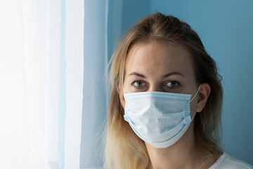 Portrait of a young girl in a medical mask, on a blue background