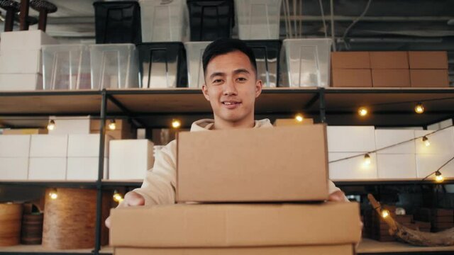 Delivery asian man holding cardboard boxes during pandemic quarantine home isolation. Fast and free supermarket Delivery. Online shopping and Express e-commerce.