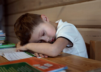 boy tired of doing home education at the table