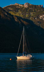 Beautiful alpine sunset view with a boat at the famous Achensee, Pertisau, Tyrol, Austria