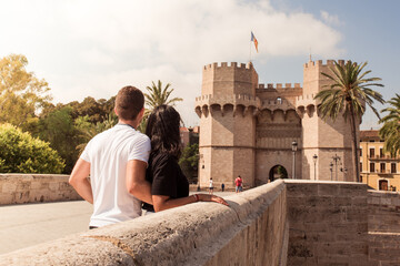 Couple observing the Serrano towers in the background, on the stone bridge. Young couple...