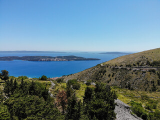 Mediterranean landscape. Hill slope and Adriatic sea in distance. Beautiful summer day in Trogir hinterland.