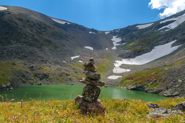 Tower of stones on the shore of a mountain lake