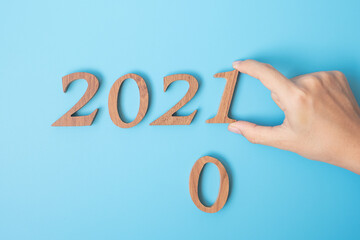 hand change 2020 to 2021 number on blue background. Resolution, strategy, solution, goal, Mission, business, New Year New You and happy holiday concepts