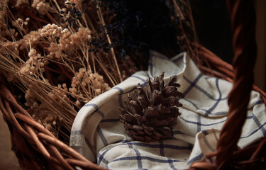 Pinecone and dried flower in the wicker basket