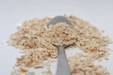 Ingredient oatmeal food for diet at the spoon and a table on the white isolated
