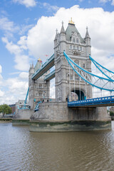 Fototapeta na wymiar The Iconic Tower Bridge Over the River Thames and Under a Cloudy Blue Sky