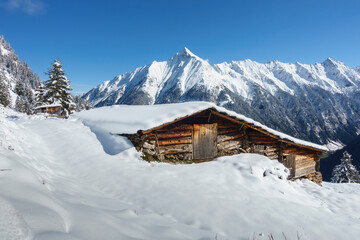 eingeschneite Berghütte in den tiroler Bergen