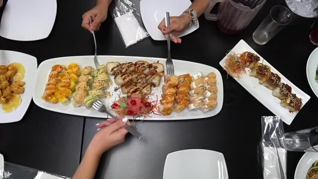 people eating Sushi in party tray