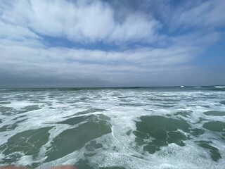 Frothy Ocean With Open Horizon and Blue Cloudy Sky