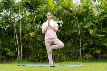 Young woman doing yoga in morning backyard at home. Outdoor workout healthy lifestyle concept.