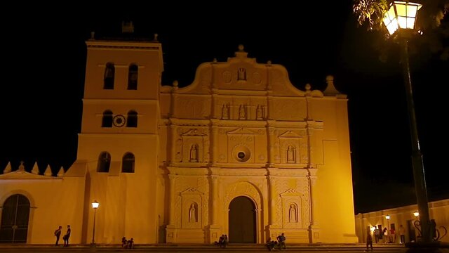 Comayagua, Comayagua/Honduras. February 19 2019. People walking outside the facade of and antique cathedral during the night