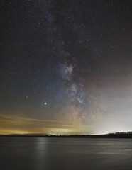 Night landscape. Lake on the background of the starry sky and the milky way.