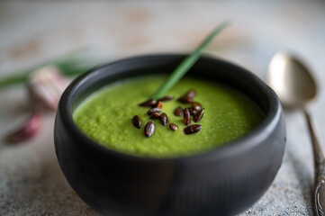 Broccoli and avocado soup in black ceramic bowl, dietary vegetable food