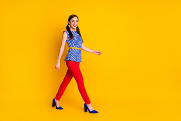 Fototapeta na wymiar Full length body size view of her she nice attractive pretty lovely winsome classy chic slim fit cheerful cheery girl walking strolling isolated bright vivid shine vibrant yellow color background