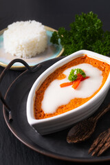 Asian food concept Thai Steamed Curried Fish, Steamed Red Curry Custard Hor Mok in white ceramic boat shape on rustic iron tray on black background