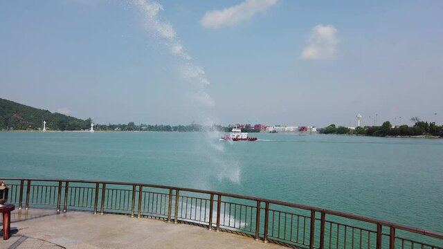 Water from Songkhla Naga sculpture sprays into sunny Gulf of Thailand