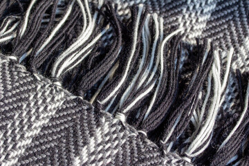 Full frame macro texture background of a black and white knitted scarf in a herringbone design pattern, with copy space