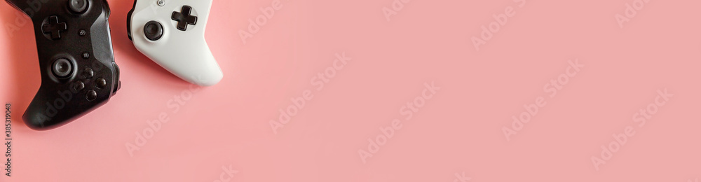 Wall mural white and black two joystick gamepad game console isolated on pastel pink colourful background. comp